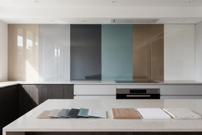 Modern kitchen with a coloured glass splashback and glass colour samples displayed on the benchtop.