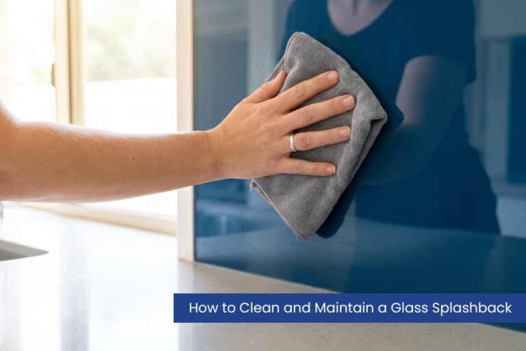 Wiping a coloured glass splashback clean with a microfibre cloth.