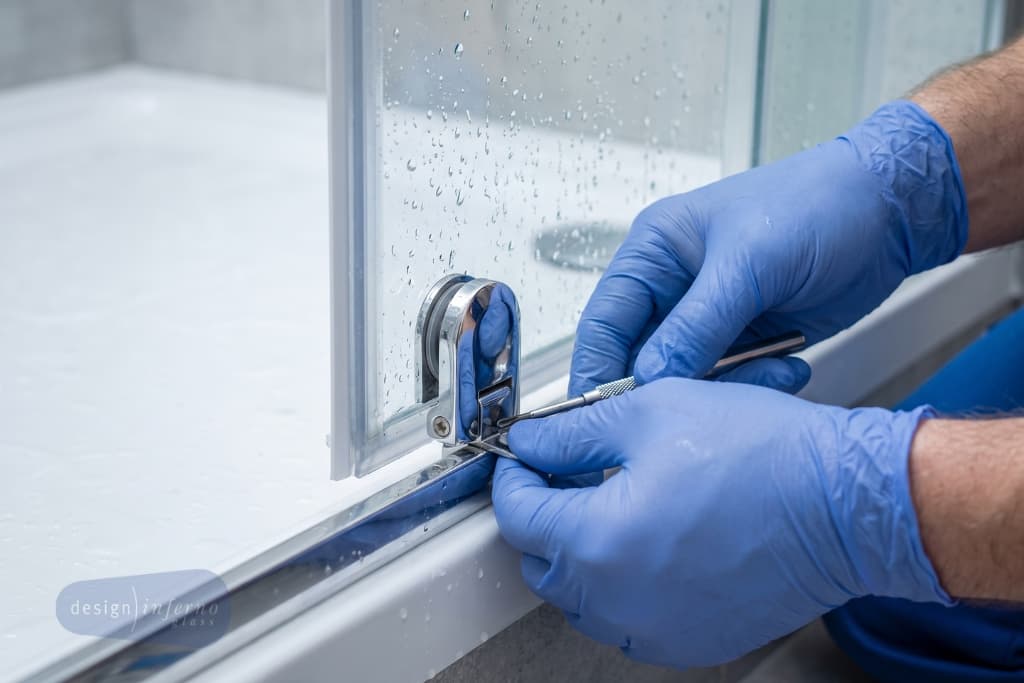 worn shower screen roller and hinge being replaced by a glazier